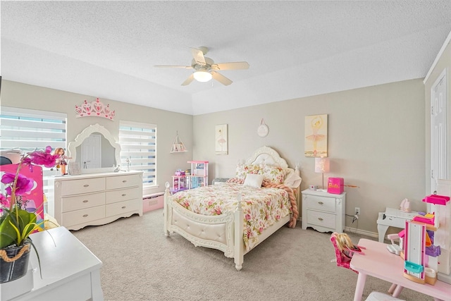 bedroom with ceiling fan, light colored carpet, and a textured ceiling