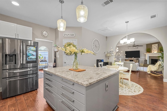 kitchen featuring white cabinetry, stainless steel fridge with ice dispenser, light stone countertops, dark hardwood / wood-style flooring, and pendant lighting