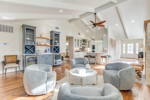 living room with beamed ceiling, bar, light hardwood / wood-style floors, and wine cooler