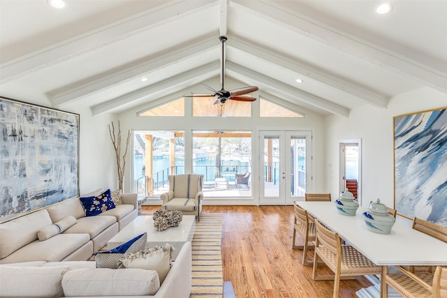 living room featuring a water view, lofted ceiling with beams, ceiling fan, and light hardwood / wood-style flooring