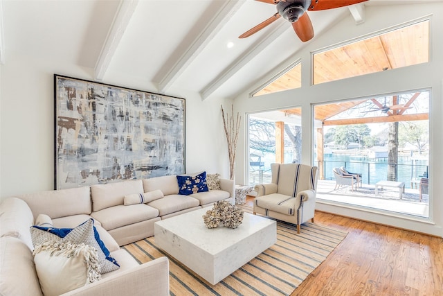 living room with ceiling fan, light hardwood / wood-style flooring, and lofted ceiling with beams