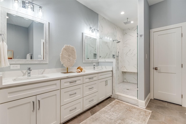 bathroom with tile patterned flooring, a tile shower, and vanity