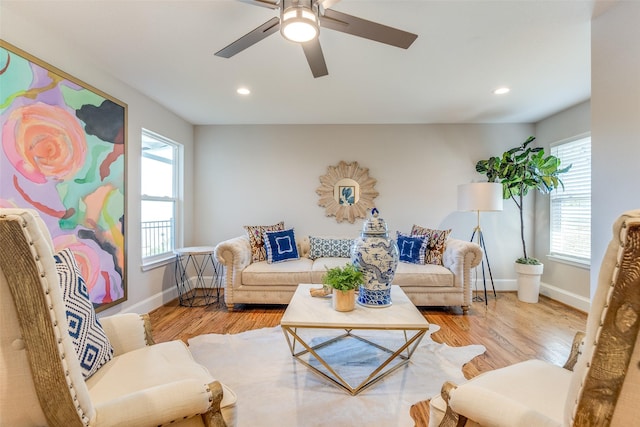 living room featuring ceiling fan, light hardwood / wood-style flooring, and a wealth of natural light