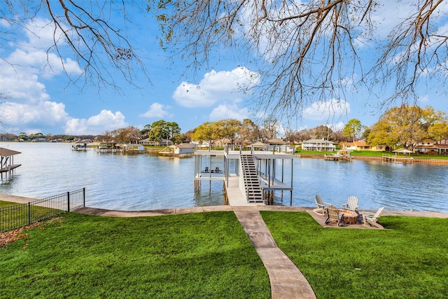 view of dock with a lawn and a water view