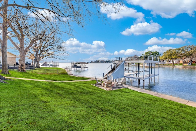 view of dock with a yard and a water view