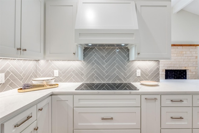 kitchen featuring white cabinets, decorative backsplash, and black electric cooktop