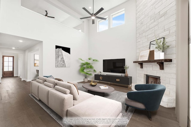 living area featuring a wealth of natural light, wood finished floors, a fireplace, and ceiling fan