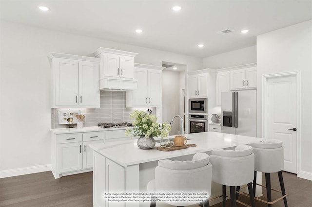 kitchen featuring white cabinets, appliances with stainless steel finishes, dark wood-style floors, and a sink