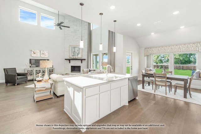 kitchen with sink, white cabinets, dishwasher, ceiling fan, and a kitchen island with sink