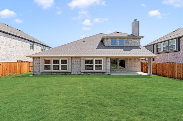 back of property featuring a shingled roof, a fenced backyard, a yard, and a patio
