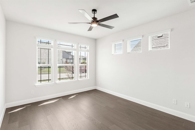 spare room featuring dark wood finished floors, baseboards, and a ceiling fan