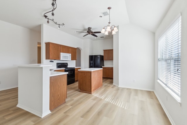 kitchen with light wood-type flooring, black appliances, pendant lighting, and a center island