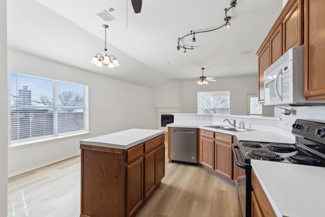 kitchen featuring sink, decorative light fixtures, vaulted ceiling, dishwasher, and electric range