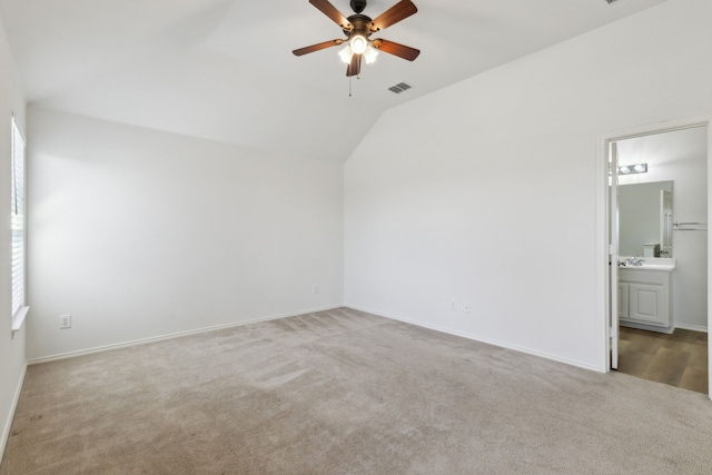 carpeted empty room featuring ceiling fan and vaulted ceiling