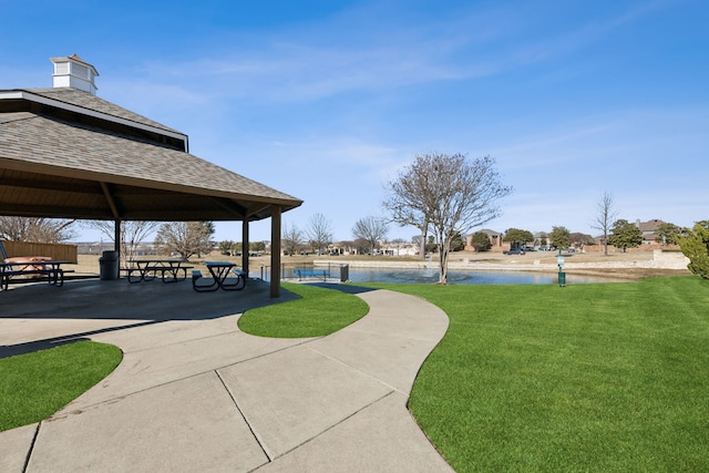 view of community with a gazebo, a lawn, and a water view