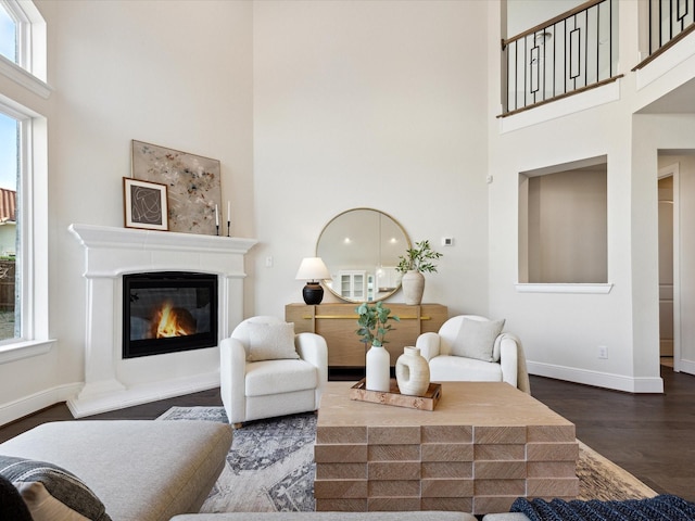 living room featuring dark wood-type flooring and a towering ceiling