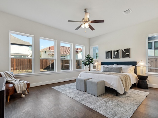 bedroom with dark hardwood / wood-style flooring, ceiling fan, and multiple windows