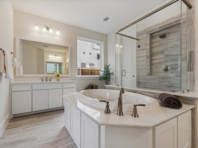 bathroom featuring a shower with door and vanity