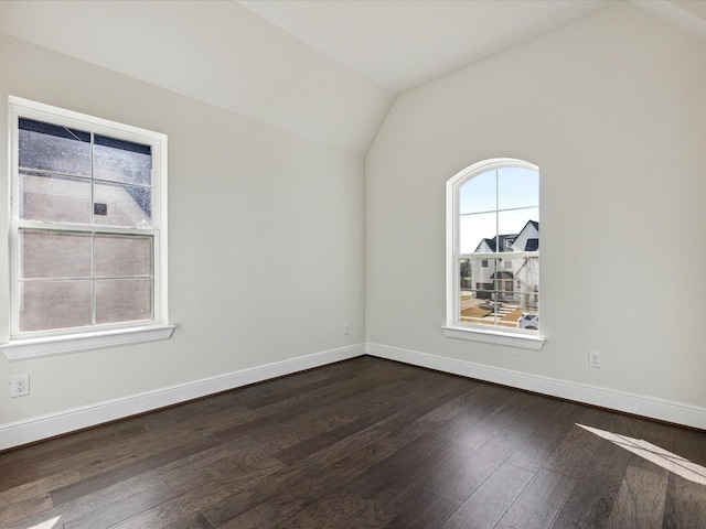 spare room featuring dark hardwood / wood-style flooring and vaulted ceiling