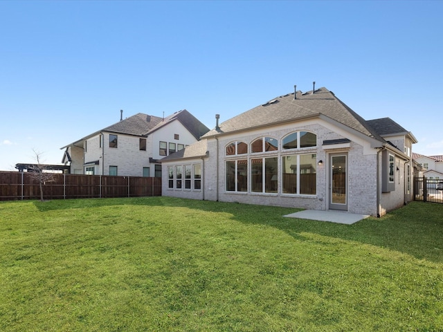 rear view of property featuring a yard and a patio