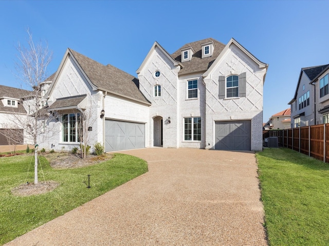 french country style house with central AC unit, a garage, and a front lawn