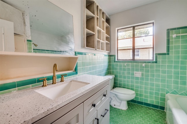 bathroom featuring tile patterned flooring, toilet, vanity, tile walls, and a bathtub