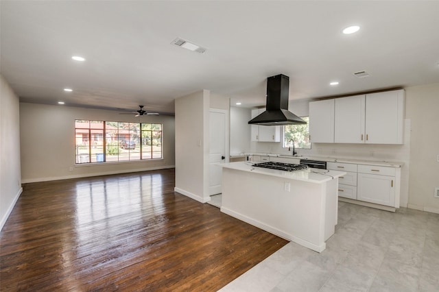 kitchen featuring white cabinetry, black dishwasher, ceiling fan, island exhaust hood, and a kitchen island