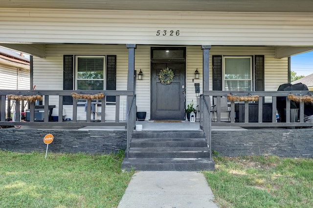 view of exterior entry featuring a porch