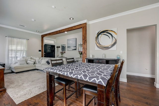 dining space with ornamental molding and dark hardwood / wood-style floors