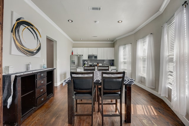 kitchen featuring dark wood-type flooring, tasteful backsplash, a kitchen island, white cabinets, and appliances with stainless steel finishes