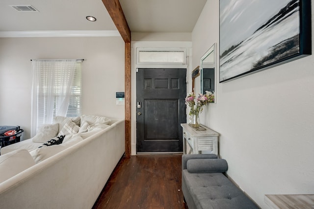 foyer with beamed ceiling, ornamental molding, and dark hardwood / wood-style flooring