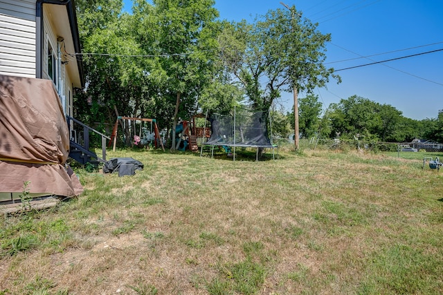 view of yard with a playground and a trampoline