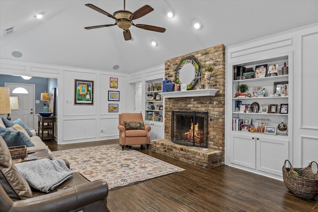 living room featuring ceiling fan, dark hardwood / wood-style floors, built in features, and a fireplace