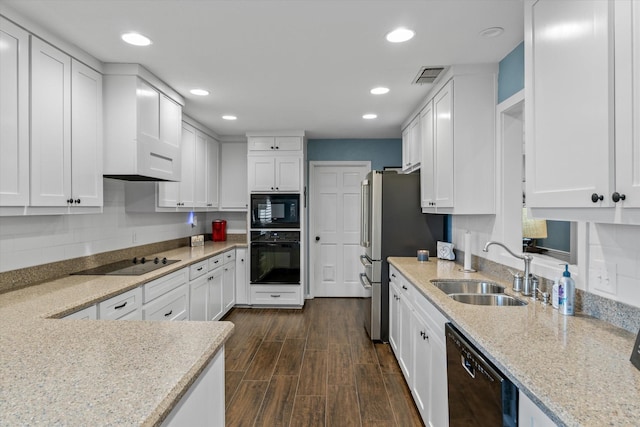 kitchen featuring black appliances, light stone counters, decorative backsplash, white cabinets, and sink