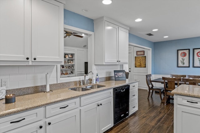 kitchen featuring sink, white cabinetry, light stone counters, ceiling fan, and decorative backsplash