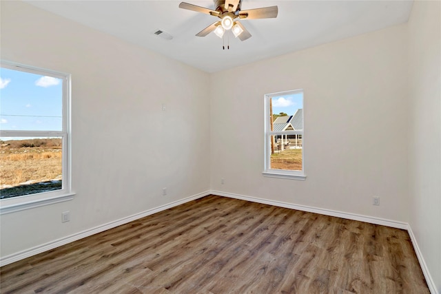 unfurnished room featuring ceiling fan, a healthy amount of sunlight, and hardwood / wood-style floors