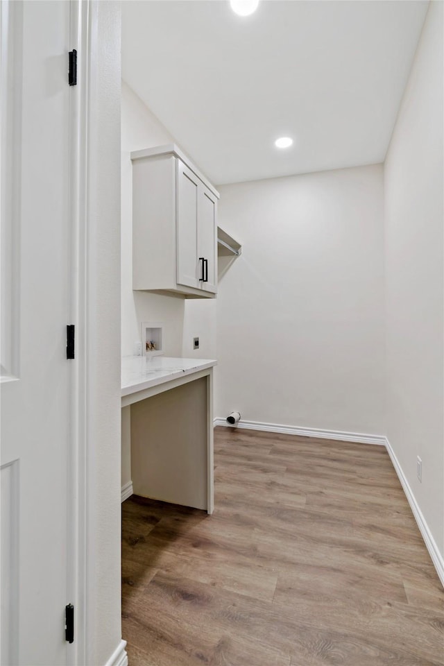 clothes washing area with hookup for a washing machine, cabinets, hookup for an electric dryer, and light hardwood / wood-style flooring