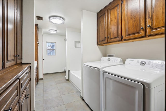 laundry room with washing machine and clothes dryer and light tile patterned floors