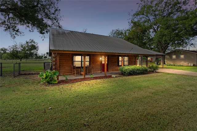 view of front of property with covered porch and a lawn