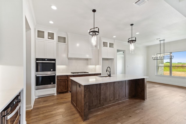 kitchen featuring visible vents, a sink, double oven, gas cooktop, and backsplash