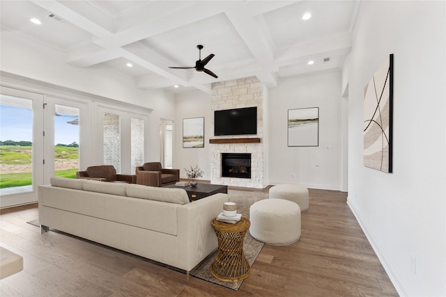 living room with baseboards, coffered ceiling, wood finished floors, beamed ceiling, and a fireplace