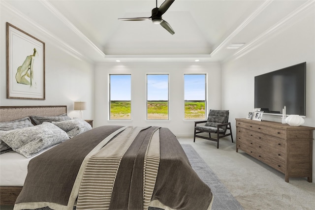 carpeted bedroom with ornamental molding, a raised ceiling, and a ceiling fan