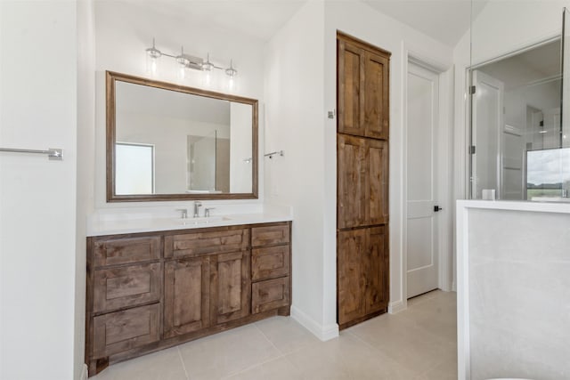 full bath featuring baseboards, vanity, and tile patterned floors