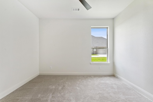 unfurnished room featuring a healthy amount of sunlight, visible vents, baseboards, and carpet flooring