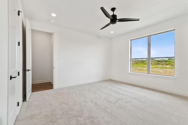 carpeted spare room featuring a ceiling fan, recessed lighting, and baseboards