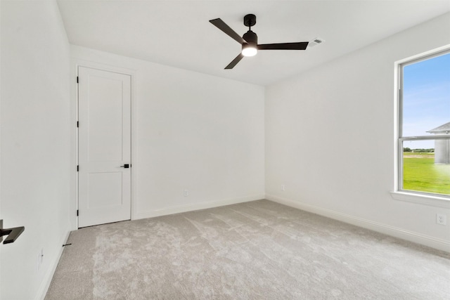 carpeted empty room featuring visible vents, baseboards, and ceiling fan