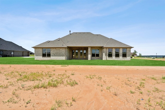 back of house with a lawn and brick siding