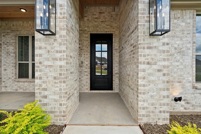 view of exterior entry featuring brick siding