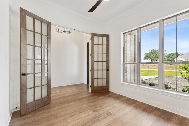 spare room with baseboards, wood finished floors, and crown molding