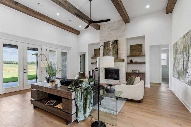 living room featuring french doors, light wood-type flooring, and a healthy amount of sunlight